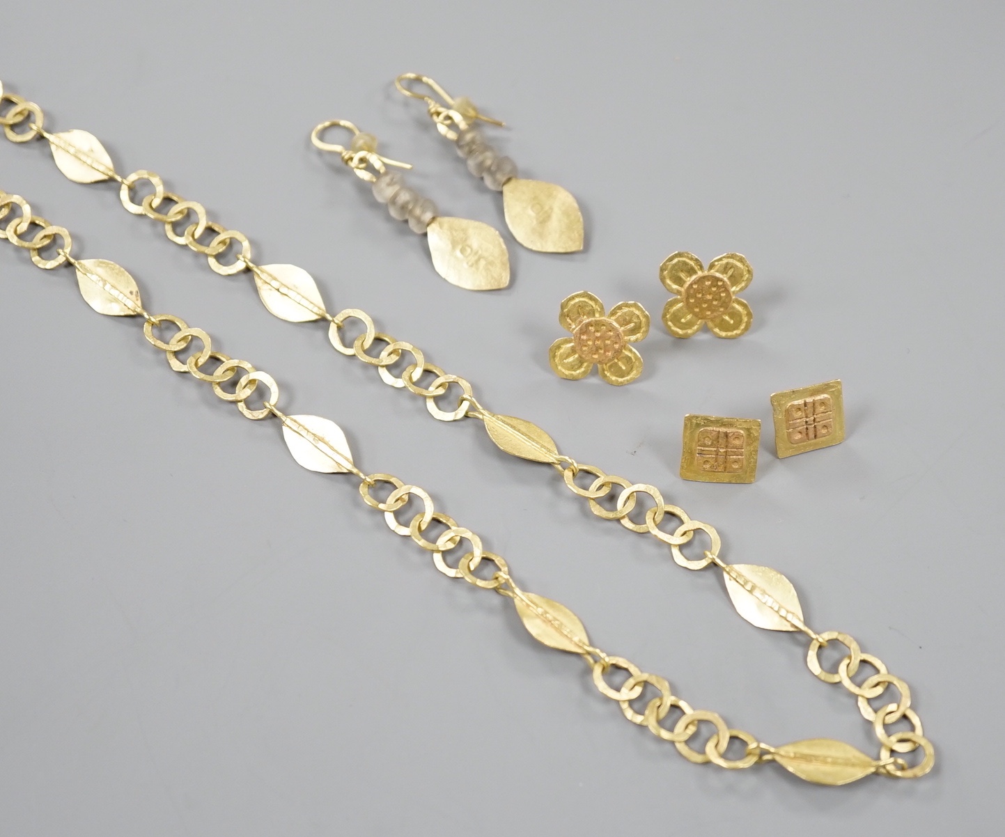 A modernist 18ct gold necklace, maker GR, London, 1999, 52cm, a pair of later drop earrings by the same maker and two other pairs of yellow metal ear studs, stamped GR only